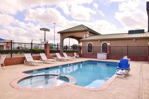- une piscine avec des chaises longues dans l'établissement Quality Inn & Suites, à Beaumont