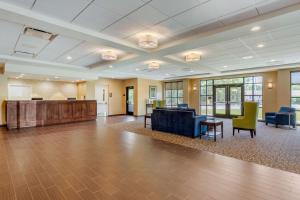 a large lobby with a waiting area and chairs and tables at Comfort Inn & Suites in Florence