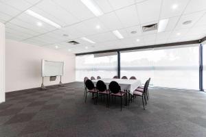 a conference room with a table and chairs and a whiteboard at Quality Inn & Suites Traralgon in Traralgon