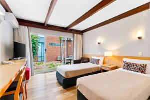 una camera d'albergo con due letti e una televisione di Quality Inn & Suites Traralgon a Traralgon