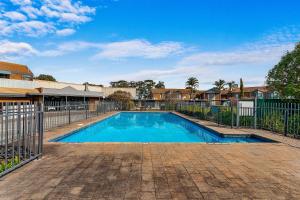 a swimming pool in a yard with a fence at Quality Inn & Suites Traralgon in Traralgon