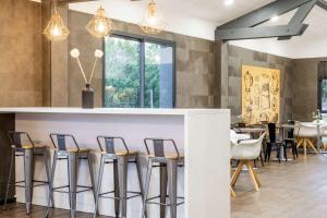 a bar in a restaurant with chairs and tables at Best Western Portes d’Aquitaine Agen Sud in Le Passage +34 photos