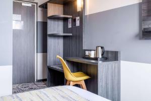 a room with a bed and a yellow chair at Best Western Portes d’Aquitaine Agen Sud in Le Passage
