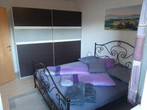 1 dormitorio con 1 cama con almohadas moradas y azules en Ferienapartment Prantner, en Grins