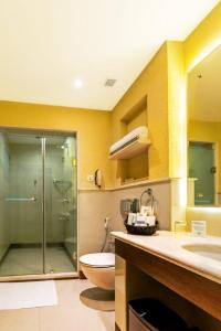 a bathroom with a shower and a toilet and a sink at Flora Airport Hotel and Convention Centre Kochi in Nedumbassery