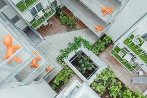 an overhead view of a courtyard with orange chairs and plants at Oliver Apartments | contactless check-in in Vienna