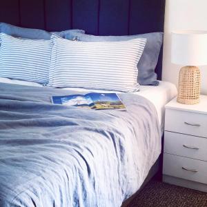 a bed with a blue blanket and pillows at Ruskin House in Byron Bay