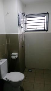 a bathroom with a toilet and a window at HD GUEST HOUSE KUANTAN in Kuantan