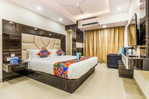 a bedroom with a large bed and a television at FabHotel Crown Heights - Nr Koramangala Club in Bengaluru