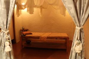 1 dormitorio con 1 cama con cortinas en una habitación en Junjungan Ubud Hotel and Spa, en Ubud
