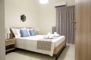 1 dormitorio con 1 cama con almohadas azules y blancas en Best House, Anakreontos, Perivolaki, Nikaia, P..., en Pireo