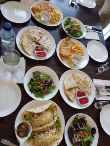 een houten tafel met borden eten erop bij Anshel Hotel Seminyak in Seminyak