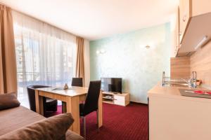 a hotel room with a table and a kitchen at Guest House Theona in Obzor