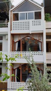 an apartment building with white balconies and windows at Saigon1984 Vintage Private Home Central District 1 with 6 bedrooms and 6 bathrooms in Ho Chi Minh City