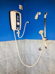 un soffione doccia in un bagno con parete blu di White House a Negombo