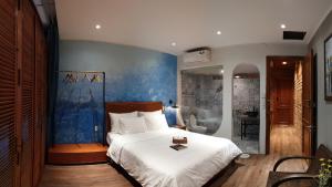 a bedroom with a bed and a blue wall at Saigon1984 Vintage Private Home Central District 1 with 6 bedrooms and 6 bathrooms in Ho Chi Minh City