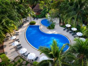 una vista aérea de una piscina con sillas y sombrillas en Ibis Phuket Patong en Patong