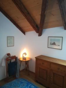 Cette chambre dispose d'une petite table et d'un plafond en bois. dans l'établissement Le fer à cheval, à Montreux