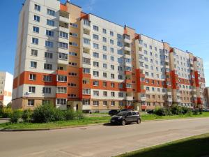 a car parked in front of a large apartment building at LikeHome Apartments in Velikiy Novgorod
