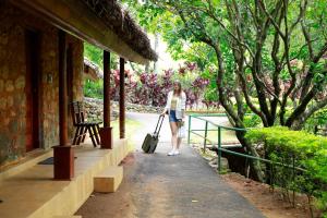 una mujer caminando por una pasarela con una maleta en Saj Vagamon Hideout, en Vagamon