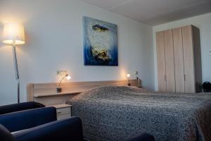 1 dormitorio con 1 cama y una pintura en la pared en Strandhotel Buren aan Zee, en Buren