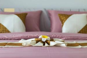 uma cama rosa com uma flor em cima em Thanycia Pool Villa em Hua Hin