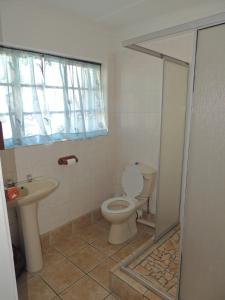 a bathroom with a toilet and a sink at Woodgrange Garden Cottages in Hibberdene +43 photos