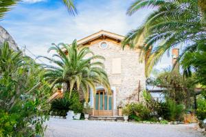 una casa in pietra con palme di fronte di Agriturismo Paradiso Di Barchi a Terracina