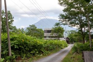 un camino de tierra con árboles y un edificio en el fondo en Cisco Moon, en Kutchan