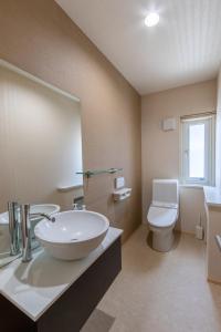 Un baño con lavabo, inodoro y espejo. en Cisco Moon, en Kutchan 28 fotos más