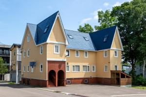 a large yellow building with a blue roof at Cisco Moon in Kutchan