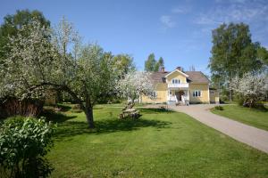 a yellow house with a tree in the yard at Eden's Garden Cottages in Svanå
