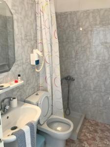 a bathroom with a toilet and a sink and a shower at Romantika in Platis Gialos
