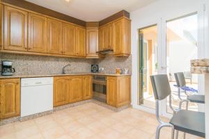 a kitchen with wooden cabinets and white appliances at Goixa in Lloseta