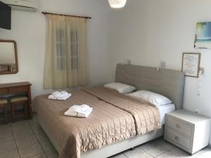a bedroom with a bed with two towels on it at Romantika in Platis Gialos