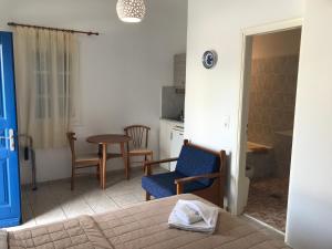 a room with a bed and a chair and a table at Romantika in Platis Gialos