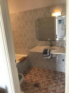 a bathroom with a sink and a toilet and a mirror at Romantika in Platis Gialos