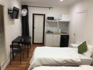 a bedroom with a bed and a table and a kitchen at Gold Coast way Brisbane in Ormeau