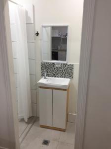 a white bathroom with a sink and a mirror at Gold Coast way Brisbane in Ormeau