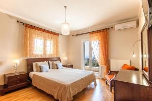 a bedroom with a bed and a desk and a window at Villa Sunny in Skiathos +65 photos