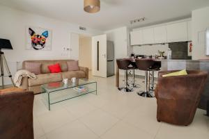 a living room with a couch and a kitchen at Appartement Danaé Antibes in Antibes
