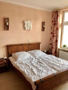 um quarto com uma cama grande e lençóis brancos em Villa Käthe FeWo Nr.4 em Kühlungsborn