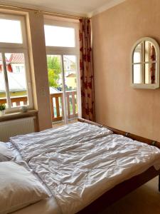 uma cama grande num quarto com duas janelas em Villa Käthe FeWo Nr.4 em Kühlungsborn