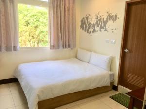 un piccolo letto in una camera con finestra di Yes I Do a Tainan