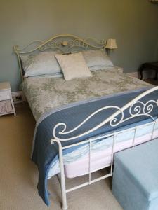 a bedroom with a bed with a blue and white comforter at Ambles in Northampton