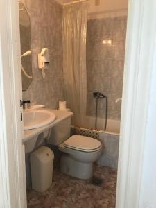 a bathroom with a toilet and a sink and a tub at Romantika in Platis Gialos