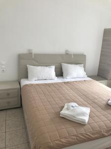 a bed with a pair of white towels on it at Romantika in Platis Gialos