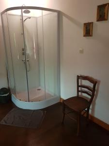 a glass shower with a wooden chair next to a wooden floor at Bed en breakfast le Chateau in Lubine