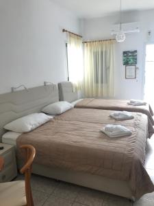 a bedroom with two beds with towels on them at Romantika in Platis Gialos