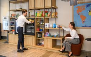 a man and a woman standing at a counter at Aparthotel Adagio Muenchen City in Munich